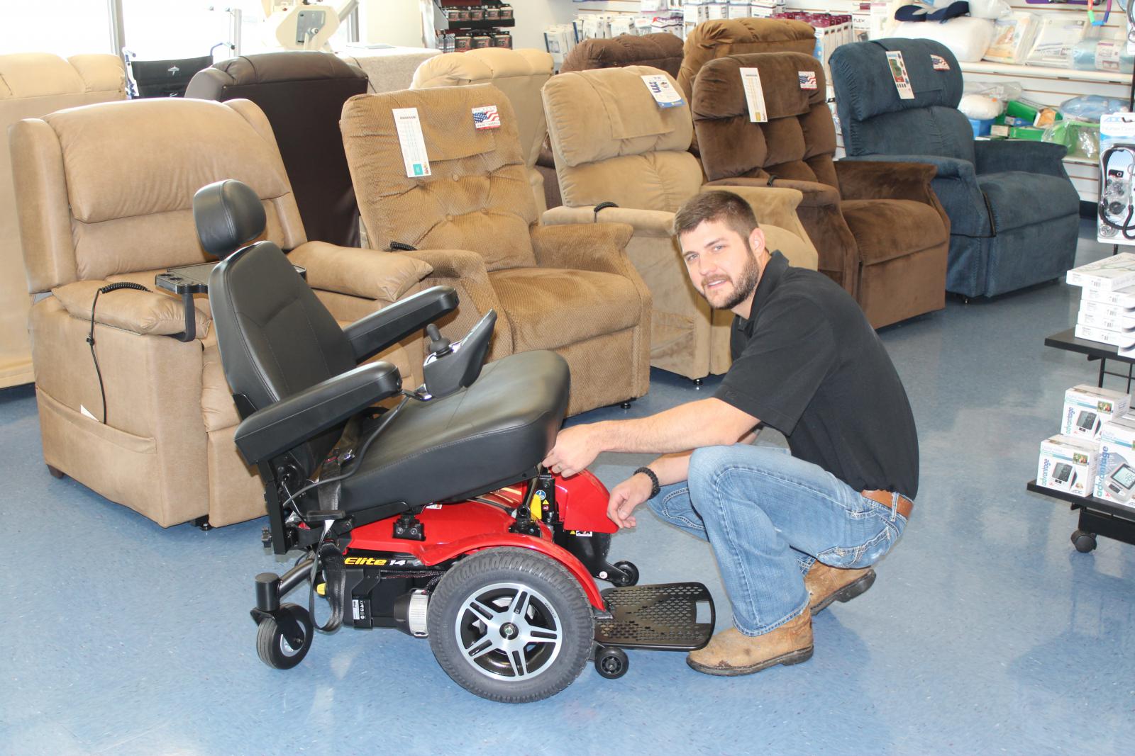 Photo of man inside of medical equipment store next to a power wheelchair.